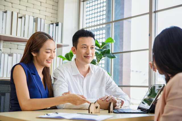 A real estate agent guiding clients in front of a California home online, representing DMT Realty Broker's local knowledge and discount real estate services.