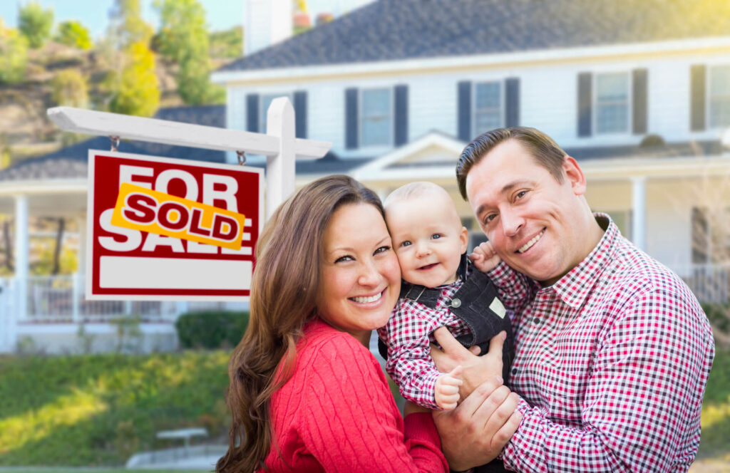 Young family in front of a San Diego home with a 'For Sale' sign, representing savings with a discount real estate broker in San Diego.