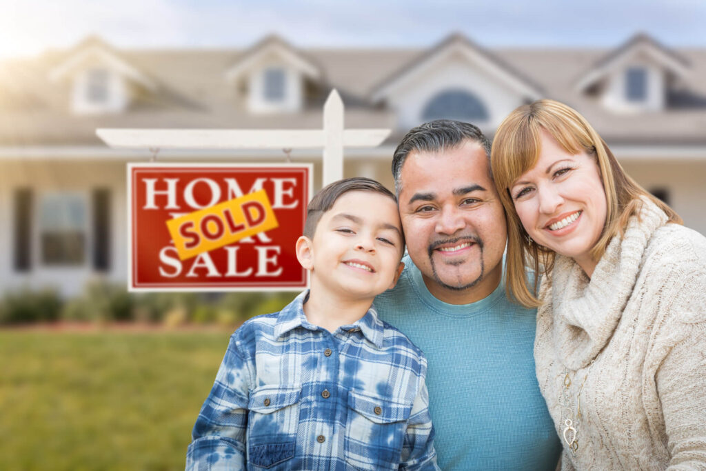 Family standing in front of a house with a 'Sold' real estate sign, representing discount real estate broker services in California that help homeowners save on commission fees.